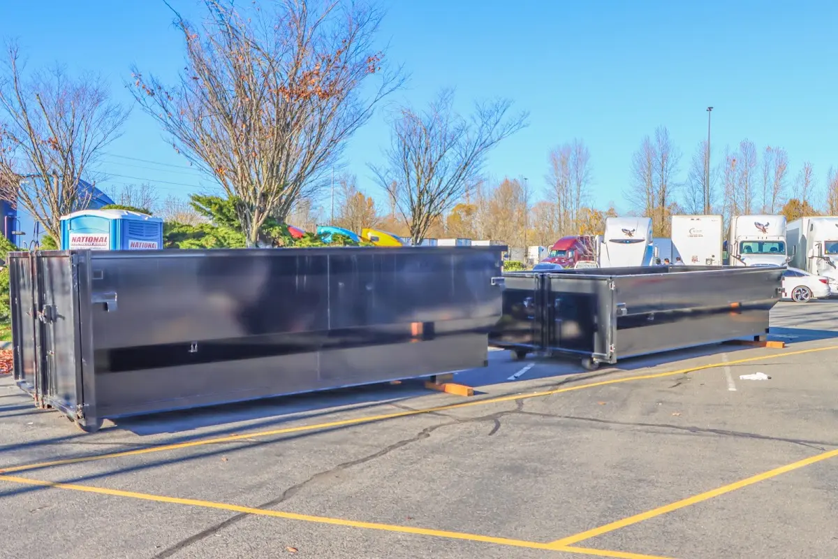 Professional dumpster rental service with roll-off container on residential driveway in Waltham